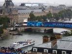 Athletes of South Korea, Ivory Coast, Costa Rica and Democratic Republic of Congo aboard a boat in the floating parade pass the Musee du Louvre on the river Seine during the opening ceremony