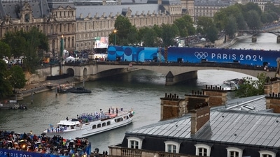 Athletes of South Korea, Ivory Coast, Costa Rica and Democratic Republic of Congo aboard a boat in the floating parade pass the Musee du Louvre on the river Seine during the opening ceremony (Pool via REUTERS)