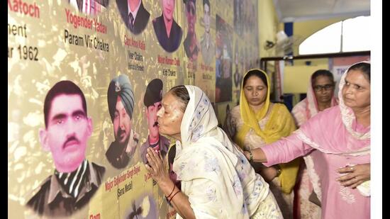 A family member shows affection to a photo of a fallen soldier during an event to mark the 25th anniversary of the Kargil Vijay Diwas in Jalandhar on Friday. (PTI)