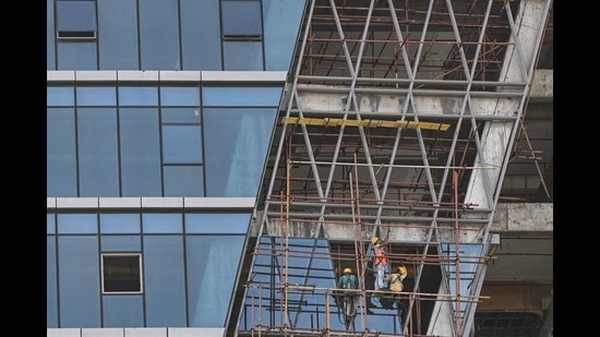 Construction labourers work on a high rise building in Kolkata on July 23, 2024. (Photo by DIBYANGSHU SARKAR / AFP) (AFP)