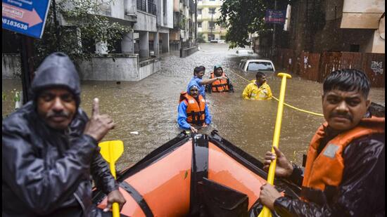 Officials during a rescue operation in a waterlogged area in Pune on Thursday. (PTI)