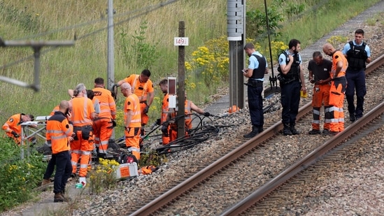 SNCF employees and French gendarmes inspect the scene of a suspected attack on the high speed railway network at Croiselles, northern France on July 26, 2024. French security forces are hunting people behind arson attacks that hobbled the country's high-speed rail network hours before the Olympic Games opening ceremony, Prime Minister Gabriel Attal said. (Photo by Denis CHARLET / AFP)