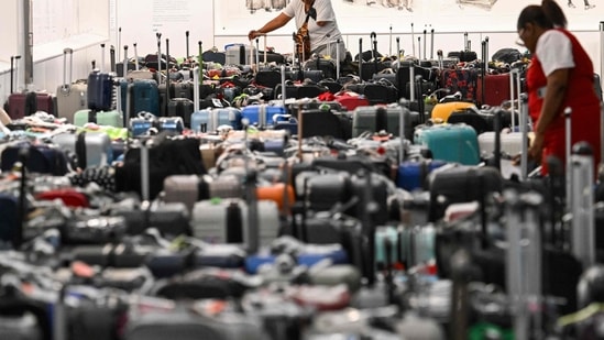 A customer looks through rows of bags awaiting reunification with their owners in the Delta Air Lines baggage claim area Los Angeles International Airport (LAX).(AFP)