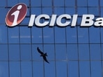 A bird flies past the facade of the ICICI bank head office in Mumbai (Reuters)