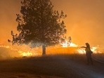 A firefighter works to extinguish the Lone Rock fire burning in Spray, Oregon, U.S. July 21, 2024 in this screengrab obtained from a video. Oregon State Fire Marshal/Handout via REUTERS/File Photo