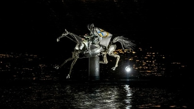 A performer on a mechanical horse carries the Olympic flag down the river Seine in Paris, France, during the opening ceremony of the 2024 Summer Olympics, Friday, July 26, 2024. (AP Photo/Lindsey Wasson) (AP)
