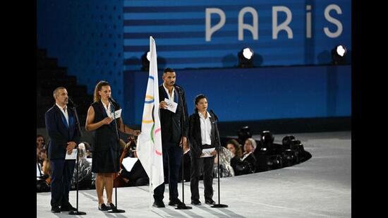 France's flag bearer Florent Manaudou (2nd R) stands on stage next to the Olympic flag at the Trocadero during the opening ceremony. (AFP)