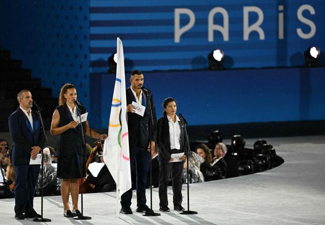France's flag bearer Florent Manaudou (2nd R) stands on stage next to the Olympic flag at the Trocadero during the opening ceremony. (AFP) France's flag bearer Florent Manaudou (2nd R) stands on stage next to the Olympic flag at the Trocadero during the opening ceremony. (AFP)