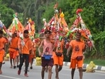 Kanwariyas carrying holy water collected from River Ganga in Haridwar going back to their hometown in Rajasthan state during the Kanwar Yatra at National Highway-48 near Signature Tower Chowk in Gurugram on Friday. (HT Photo)