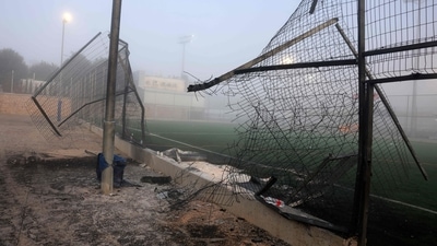 A damaged gate and debris are seen at a football pitch after a reported strike from Lebanon fell in Majdal Shams village in the Israeli-annexed Golan area on July 28, 2024. Israel's military said Hezbollah fired the rocket from Lebanon, hitting a football pitch in the Druze town of Majdal Shams and killing the youngsters, who were between 10 and 20 years old. Another 18 youths were wounded in the attack, said the emergency services. (Photo by Menahem Kahana / AFP) (AFP) A damaged gate and debris are seen at a football pitch after a reported strike from Lebanon fell in Majdal Shams village in the Israeli-annexed Golan area on July 28, 2024. Israel's military said Hezbollah fired the rocket from Lebanon, hitting a football pitch in the Druze town of Majdal Shams and killing the youngsters, who were between 10 and 20 years old. Another 18 youths were wounded in the attack, said the emergency services. (Photo by Menahem Kahana / AFP) (AFP)