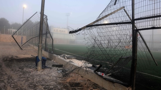 A damaged gate and debris are seen at a football pitch after a reported strike from Lebanon fell in Majdal Shams village in the Israeli-annexed Golan area on July 28, 2024. Israel's military said Hezbollah fired the rocket from Lebanon, hitting a football pitch in the Druze town of Majdal Shams and killing the youngsters, who were between 10 and 20 years old. Another 18 youths were wounded in the attack, said the emergency services. (Photo by Menahem Kahana / AFP)(AFP)