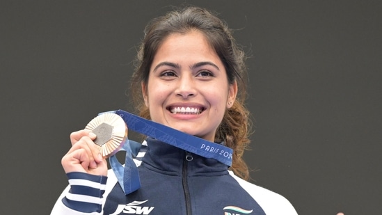 Manu Bhaker poses for a photograph with her bronze medal after finish third in the 10m air pistol women's final round at the 2024 Summer Olympics, France, Sunday, July 28, 2024.(PTI)