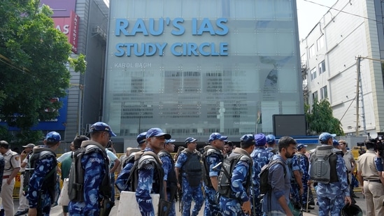 Security personnel stand guard near a UPSC exam coaching centre after three civil services aspirants died when the basement of the coaching centre was flooded. (PTI)