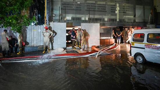 Rescue workers pump out water from the basement on Sunday. (Sanchit Khanna/HT Photo)