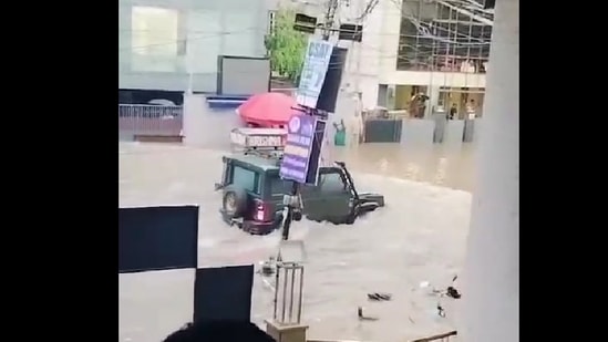 After an SUV passes the road, water hits the gate of the coaching institute, and the gates break as it is unable to withstand the pressure of flood waters.(@htTweets )