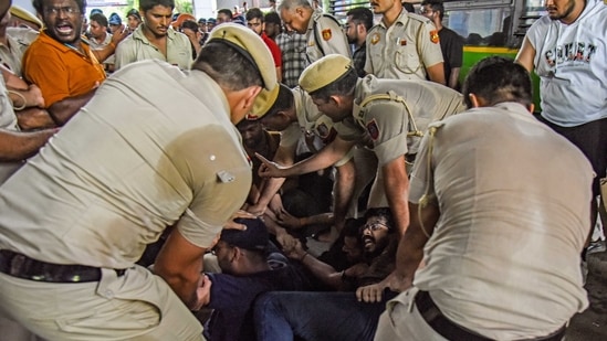 Police personnel detain students during their protest after three civil service aspirants died due to flooding in the basement of the Old Rajinder Nagar's coaching centre, at Karol Bagh Metro Station in New Delhi on Sunday.(ANI)