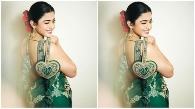 Assisted by celebrity fashion stylist Meagan Concessio, Rashmika accessorised her look with golden traditional statement earrings and a matching green potli bag featuring her initials, RM. (Instagram/@rashmika_mandanna)