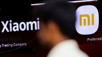 A man walks past a logo of Xiaomi, a Chinese manufacturer of consumer electronics, outside a shop. (Reuters)