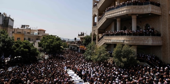 Druze elders and mourners surround the coffins of 10 of the 12 people killed in a rocket strike from Lebanon on July 28. (Photo by Jalaa MAREY/ AFP)