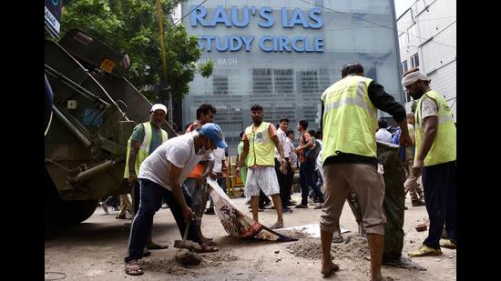 MCD workers outside the 'Rao IAS Study Centre' in Old Rajinder Nagar in New Delhi. (ANI Photo)