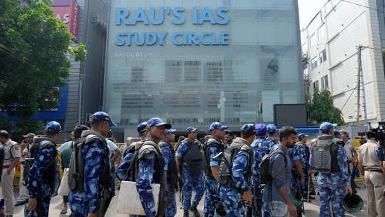 Security personnel stand guard near a UPSC exam coaching centre after three civil services aspirants died when the basement of the coaching centre was flooded following heavy rain in New Delhi, on Sunday. (PTI)