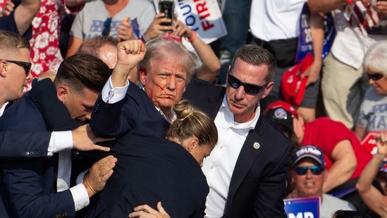 Republican candidate Donald Trump is seen with blood on his face surrounded by secret service agents as he is taken off the stage at a campaign event at Butler Farm Show Inc. in Butler, Pennsylvania, July 13, 2024. Donald Trump was hit in the ear in an apparent assassination attempt by a gunman at a campaign rally on Saturday, (AFP)