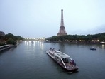 Team boats on the Siene with the Eiffel Tower in the background during the opening ceremony of the 2024 Summer Olympics in Paris, France, Friday, July 26, 2024