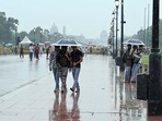 Visitors at Kartavya Path, New Delhi face light rain on Tuesday as high humidity makes Delhi swelter. (Sanjeev Verma/HT Photo)