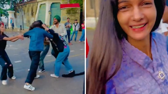 The image shows a woman making a reel while a group of people fight in the background. (Screengrab)