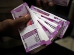 A cashier displays the new 2000 Indian rupee banknotes inside a bank in Jammu. (Reuters)