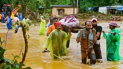 Relief personnel carry the body of a victim, during a search and rescue operation at a site following landslides in Wayanad. (AFP) Relief personnel carry the body of a victim, during a search and rescue operation at a site following landslides in Wayanad. (AFP)