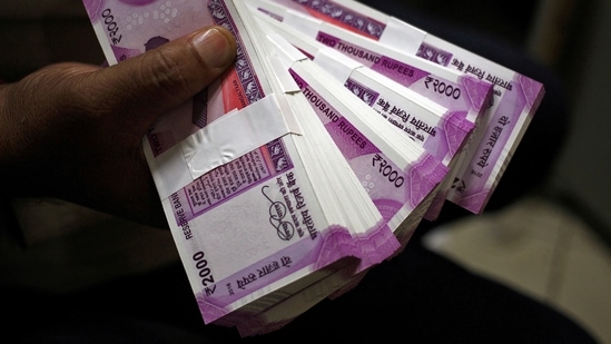 A cashier displays the new 2000 Indian rupee banknotes inside a bank in Jammu. (Reuters)