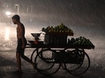 Street vendor runs for cover during the evening rain after a humid summer, in Noida, Delhi-NCR. Rain intensity reduced after 8.30 pm, but scattered rains continued till 3 am in the national capital region.((Photo by Sunil Ghosh / Hindustan Times))