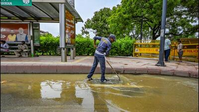 An NDMC worker clears water from Rafi Marg near Udyog Bhawan. (Raj K Raj/HT Photo) An NDMC worker clears water from Rafi Marg near Udyog Bhawan. (Raj K Raj/HT Photo)