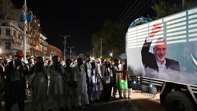 Activists and supporters of Pakistan's Jamaat-e-Islami (JI) attend an absentee funeral prayers for slain Hamas political leader Ismail Haniyeh, next to his poster in Rawalpindi on July 31, 2024, following his assassination in an air strike in Tehran. (Photo by Aamir QURESHI / AFP) (AFP) Activists and supporters of Pakistan's Jamaat-e-Islami (JI) attend an absentee funeral prayers for slain Hamas political leader Ismail Haniyeh, next to his poster in Rawalpindi on July 31, 2024, following his assassination in an air strike in Tehran. (Photo by Aamir QURESHI / AFP) (AFP)