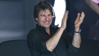 TOPSHOT - US actor Tom Cruise watches the victory ceremony of the women's 4x100m freestyle relay swimming event at the Paris 2024 Olympic Games at the Paris La Defense Arena in Nanterre, west of Paris, on July 27, 2024. (AFP / Oli SCARFF) TOPSHOT - US actor Tom Cruise watches the victory ceremony of the women's 4x100m freestyle relay swimming event at the Paris 2024 Olympic Games at the Paris La Defense Arena in Nanterre, west of Paris, on July 27, 2024. (AFP / Oli SCARFF)