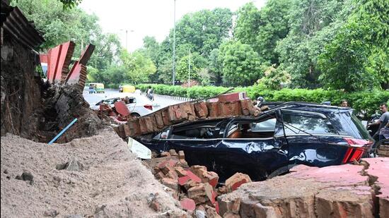 A damaged car under the debris of a boundary wall in Daryaganj. (PTI)