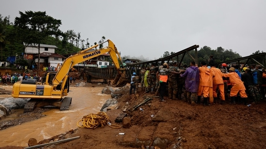 An excavator along with army personnel and volunteers lift a portion of a bridge during its re-construction after landslides hit Chooralmala in Wayanad district.(Reuters)