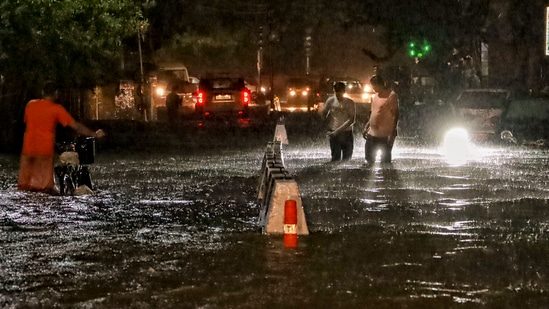 People wade through a waterlogged road during rain at Jangpura area, in New Delhi, Wednesday, July 31, 2024. (PTI)