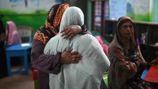 Survivors of the landslide console each other as they rest at a relief camp in Wayanad, in India's Kerala state on July 31, 2024. (Photo by Idrees MOHAMMED / AFP)(AFP)