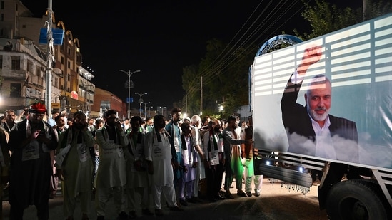 Activists and supporters of Pakistan's Jamaat-e-Islami (JI) attend an absentee funeral prayers for slain Hamas political leader Ismail Haniyeh, next to his poster in Rawalpindi on July 31, 2024, following his assassination in an air strike in Tehran. (Photo by Aamir QURESHI / AFP)(AFP)