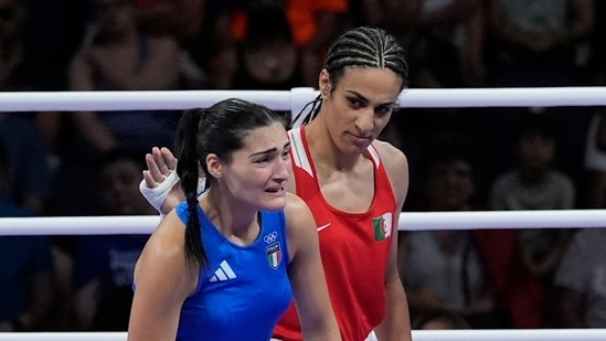 Algeria's Imane Khelif, red, next to Italy's Angela Carini, at the end of their women's 66kg preliminary boxing match at the 2024 Summer Olympics