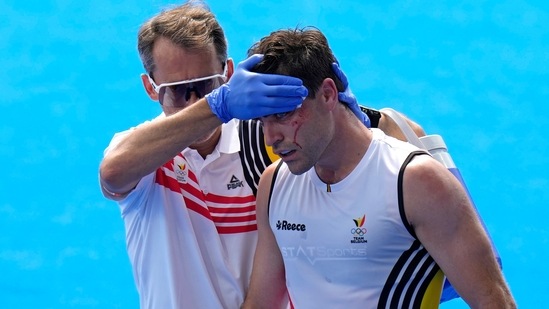 Belgium's Arthur De Sloover is helped by a team support staff as he walks off the pitch after getting hurt during the men's Pool B match.(AP)