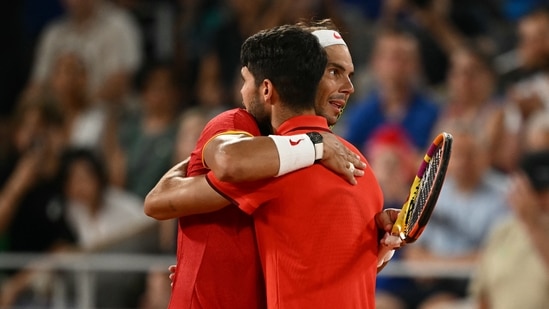 Spain's Rafael Nadal (R) and Spain's Carlos Alcaraz (L) embrace after losing their men's doubles quarter-final tennis match on Court Philippe-Chatrier at the Roland-Garros Stadium during the Paris 2024 Olympics(AFP)