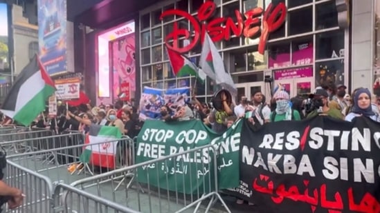Anti-Israel protesters hold up portrait of Ismail Haniyeh, wave pro-terror flag in Times Square (@SpyderMonkey0_0/X)