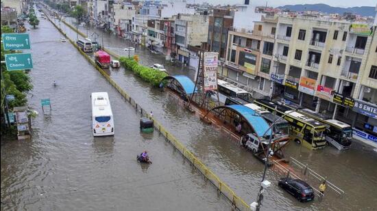 Vehicles move through a waterlogged road after rains, in Jaipur. (PTI photo)