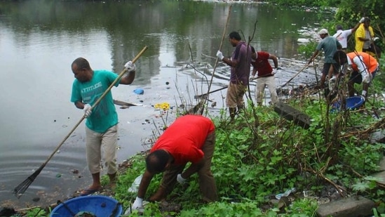 Volunteers collect garbage from the waterbody near the Charkop mangroves.(HT Photo)