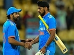 India's captain Rohit Sharma (L) shakes hands with Arshdeep Singh (R) after the match
