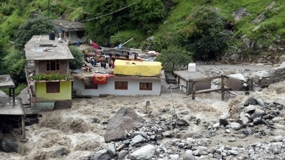 Houses after some part washed away in the river following a flood caused by a cloudburst, at the Baladhi village in Kullu on Thursday. (ANI) (HT_PRINT)