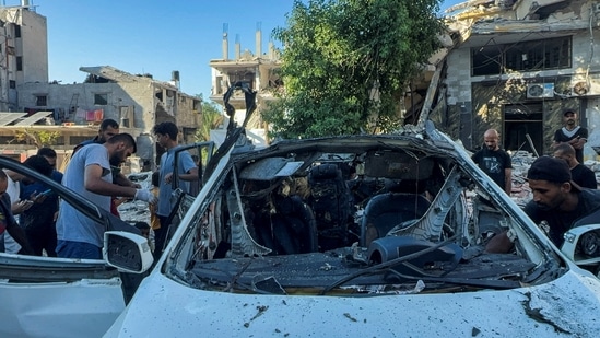 Palestinians inspect a vehicle where Al Jazeera TV said its reporter Ismail al-Ghoul and cameraman Ramy El Rify were killed in an Israeli strike, in Gaza City July 31, 2024. (REUTERS/Ayman Al Hassi)